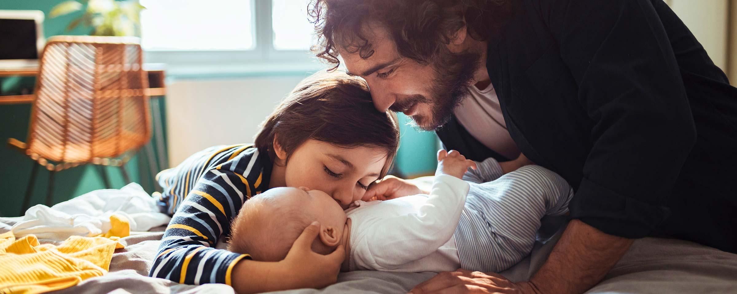 Vater mit seinem Baby und Kleinkind.