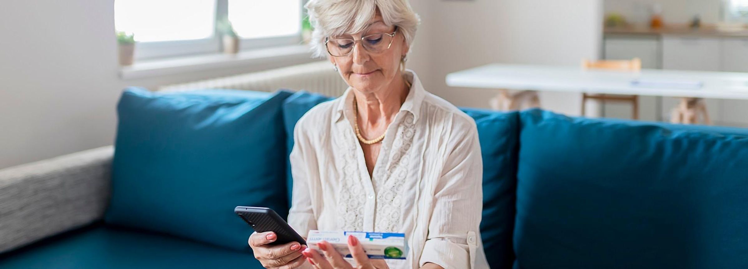 Eine Frau informiert sich mit ihrem Smartphone über ein Arzneimittel