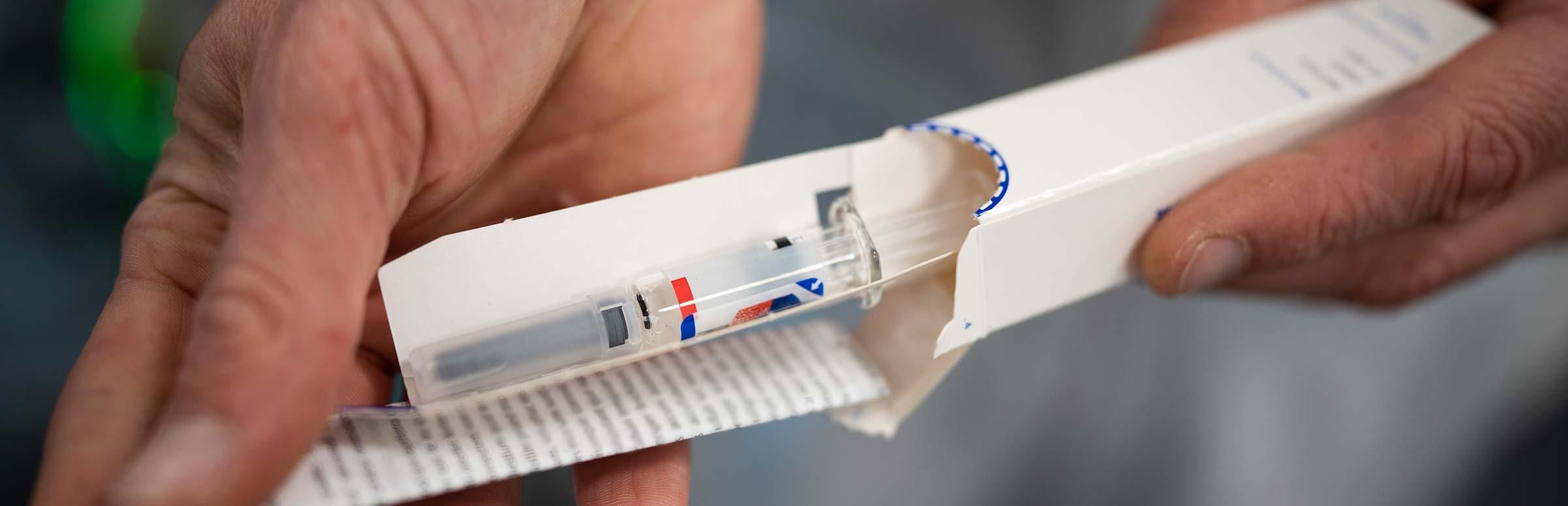 Eine Spritze wird aus einer Verpackung entnommen